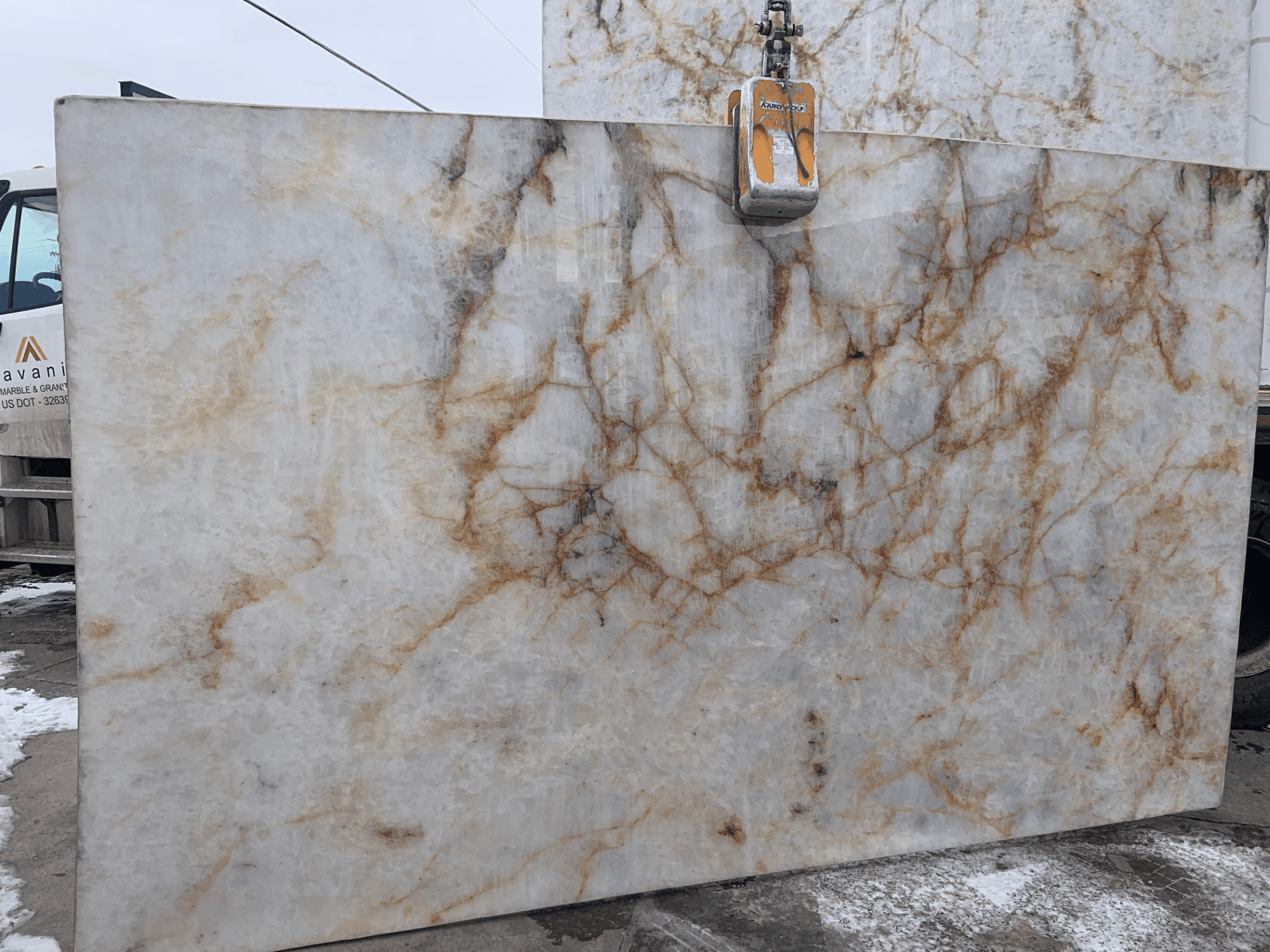 A white quartzite slab with rust and gold veins